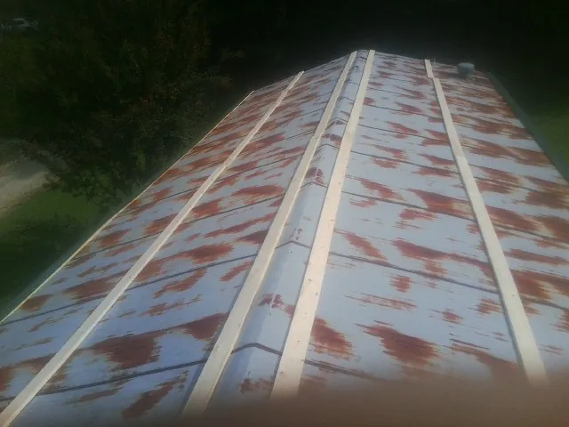 Rusted metal roof panels with new wood purlins before replacement — Storm Damage Roof Repair in Maynard by Roofing Brothers