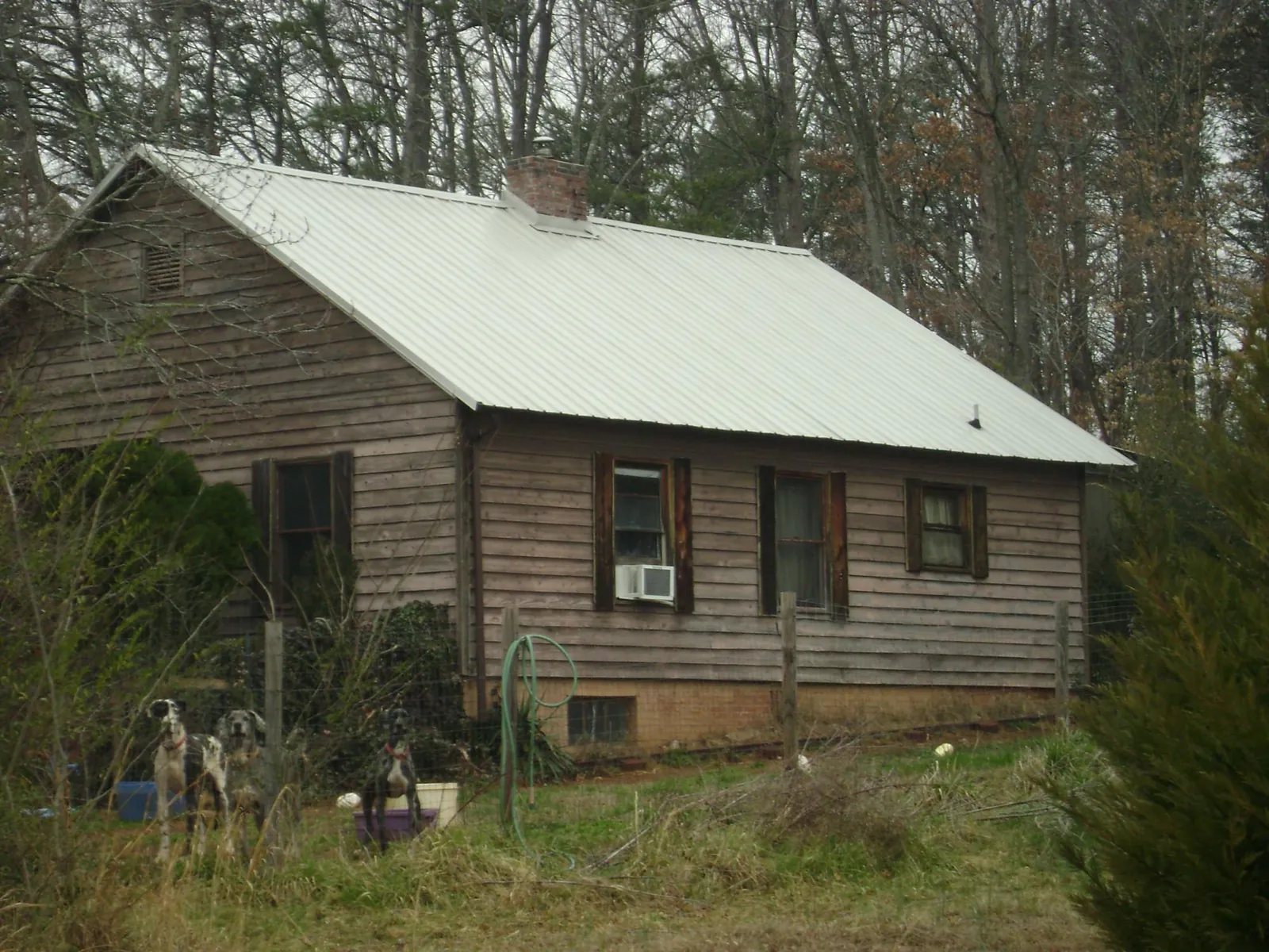 White metal roof on an old wood sided farmhouse, from a Metal Roof Installation job in Maynard